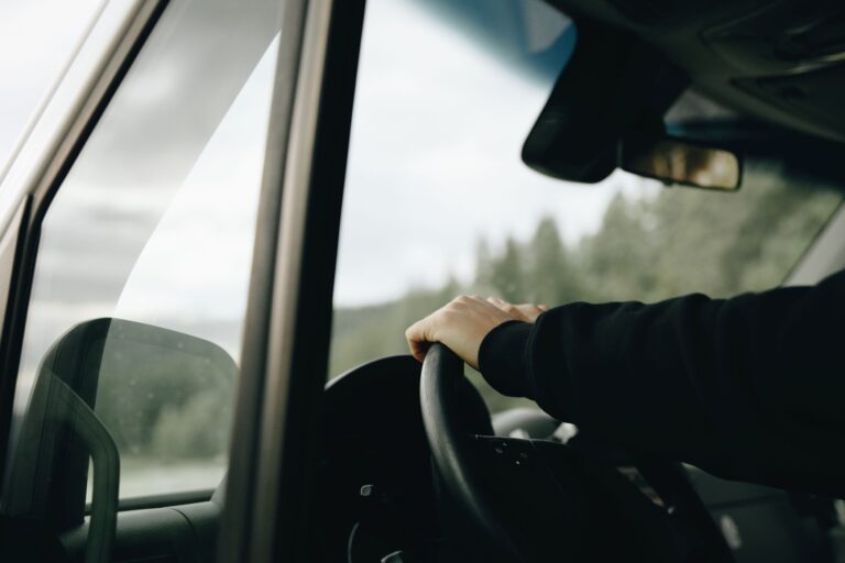Blog Pt 11 Conductor de flota con la mano en el volante de un vehículo utilitario